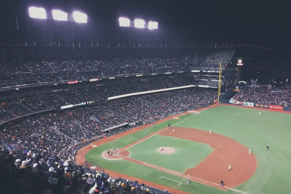 Packed stadium under floodlights during a night game