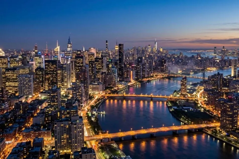 City skyline and river bridges lit up at dusk